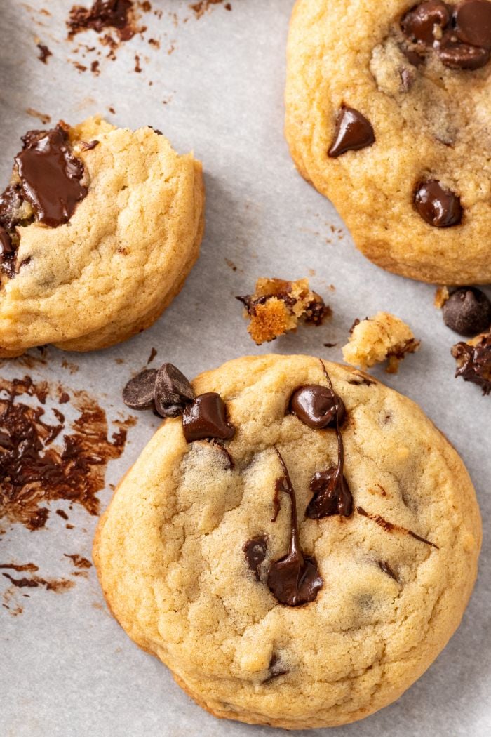 top down view of chocolate chip cookies, one of which is broken into pieces